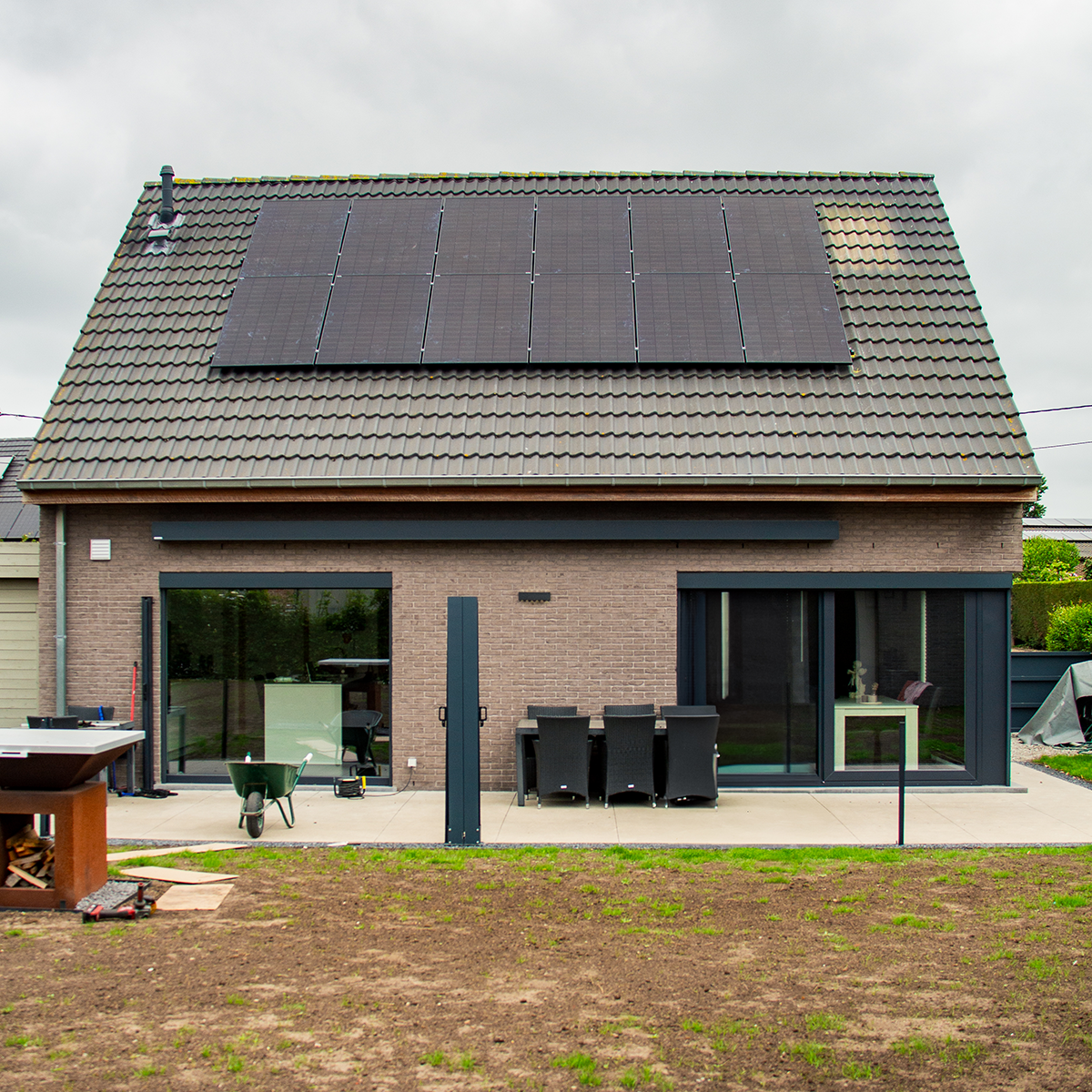 Achtergevel van de woning van Pieter in Lichtervelde met 12 zwarte zonnepanelen geplaatst door NRG-TEC.